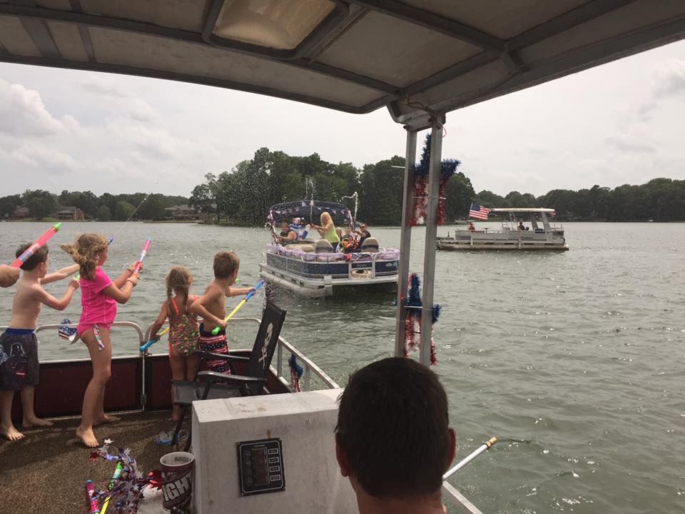 Kids on a pontoon boat preparing the squirt other participants