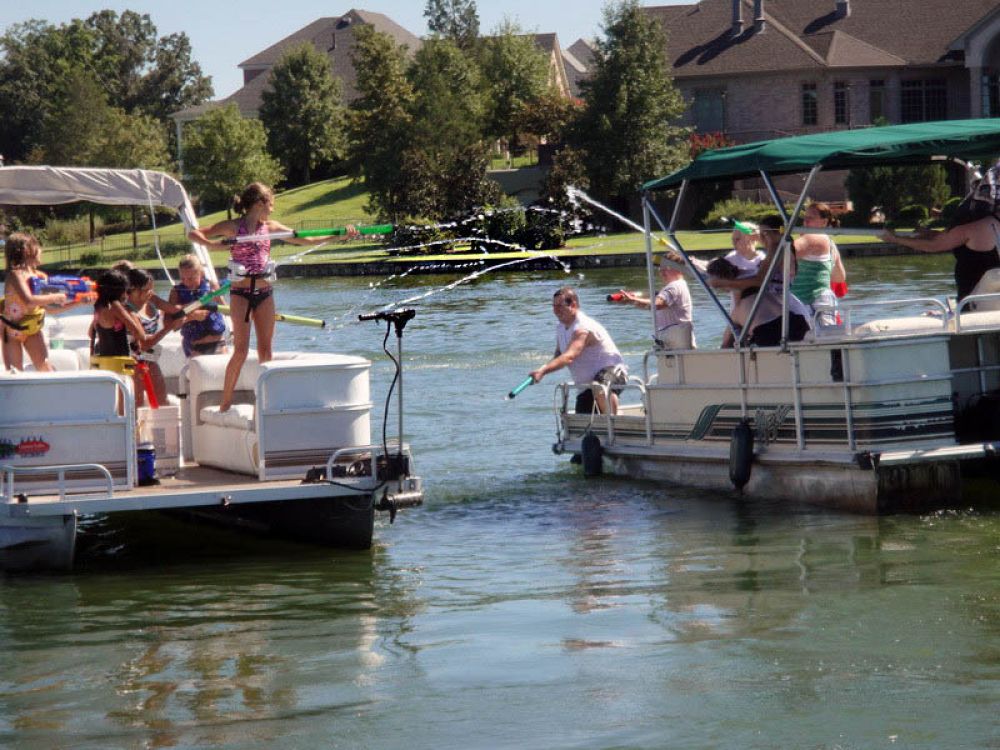 Boats with passengers squirting each other with squirt guns